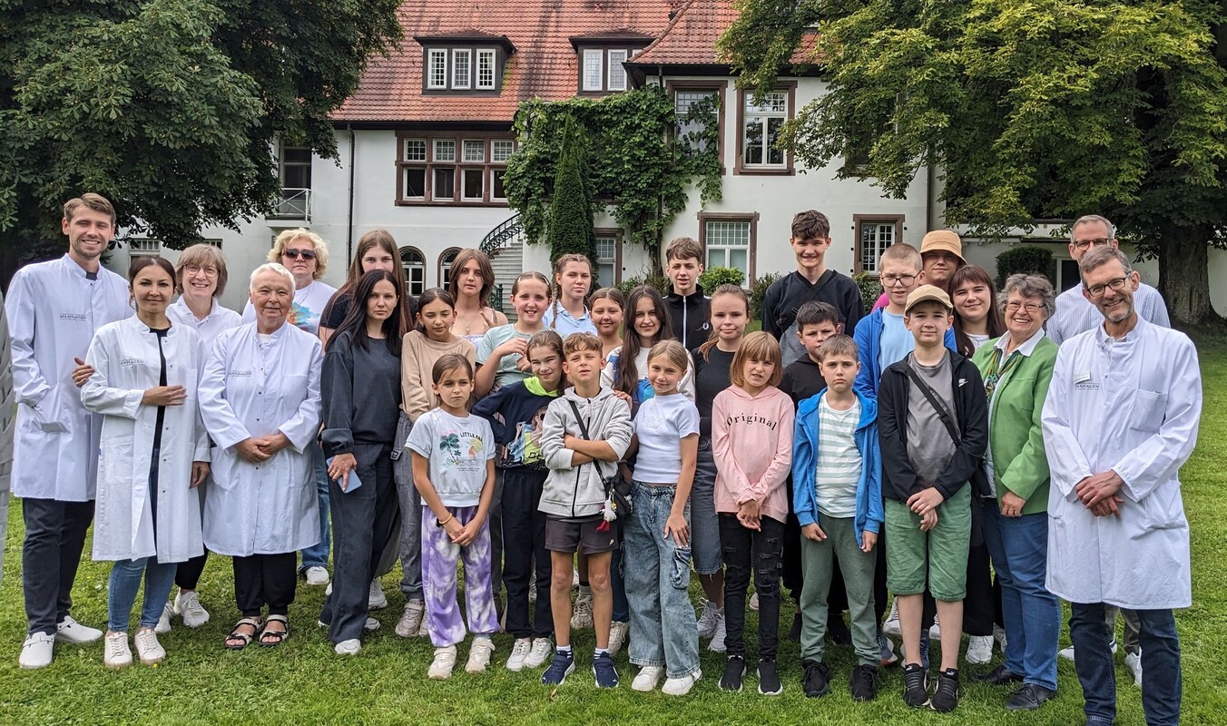 Gruppenbild_Pryvit Kinder 2025 im Park der Klinik Manhagen mit Ärzteteam
